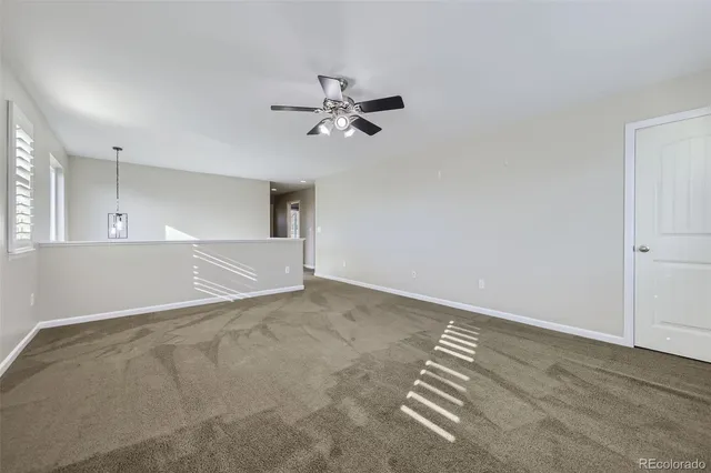a view of empty room with ceiling fan