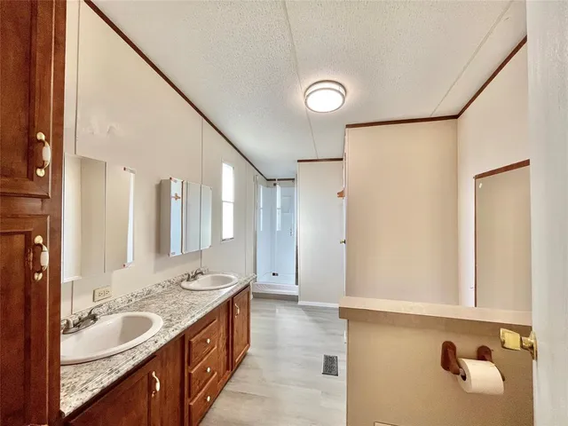 a spacious bathroom with a granite countertop sink and a mirror