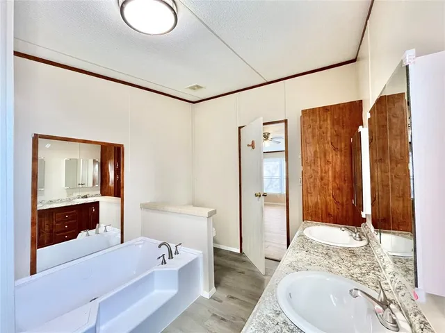 a spacious bathroom with a granite countertop tub sink and mirror