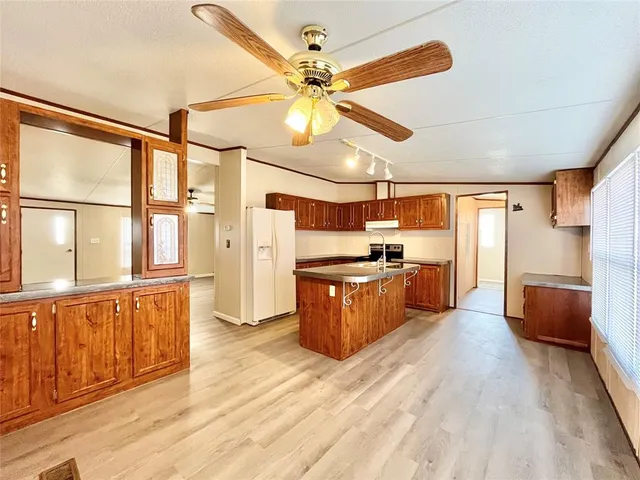 a large kitchen with stainless steel appliances kitchen island granite countertop a sink and cabinets