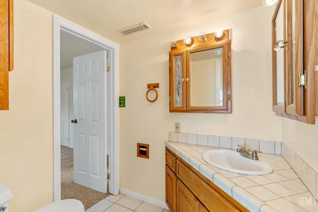 a bathroom with a granite countertop sink and a mirror