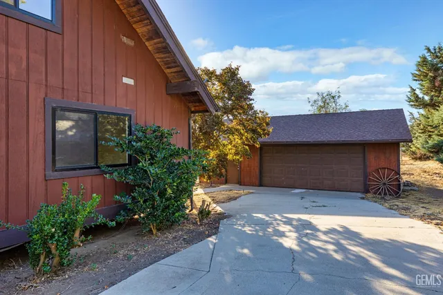a view of backyard with wooden fence and large trees