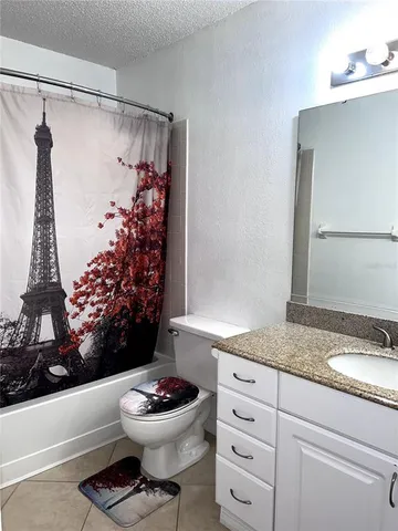 a bathroom with a granite countertop sink mirror vanity and toilet