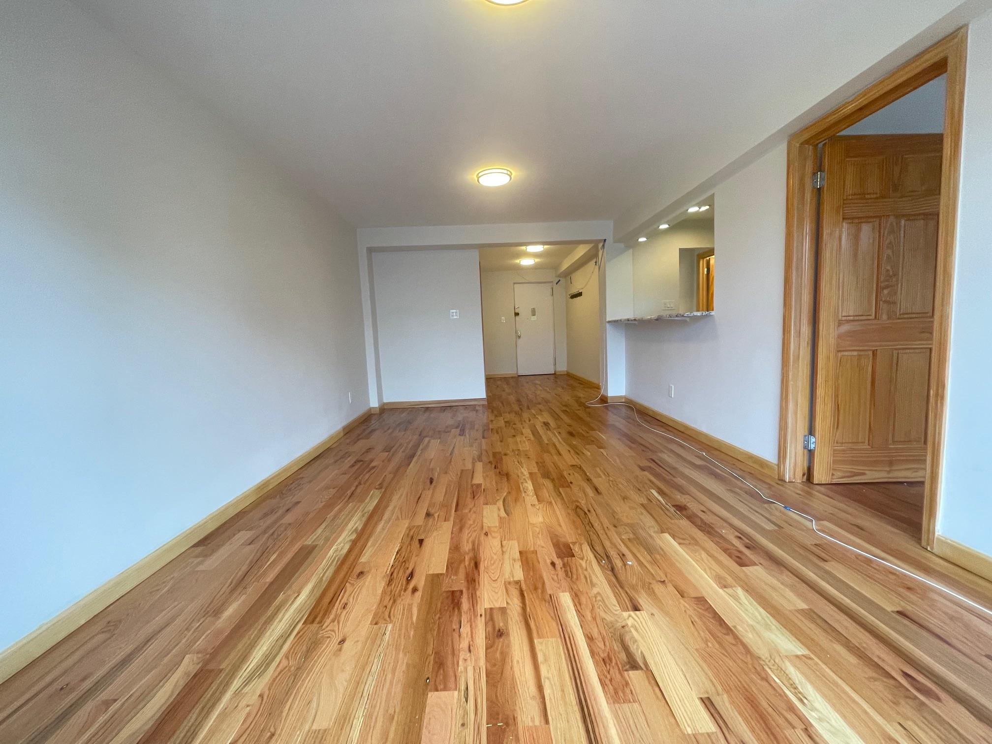 59-30 108th Street, Unit 2JJ Queens, NY 11368 - Photo 12 of 15 Unfurnished living room featuring light wood-style flooring and baseboards