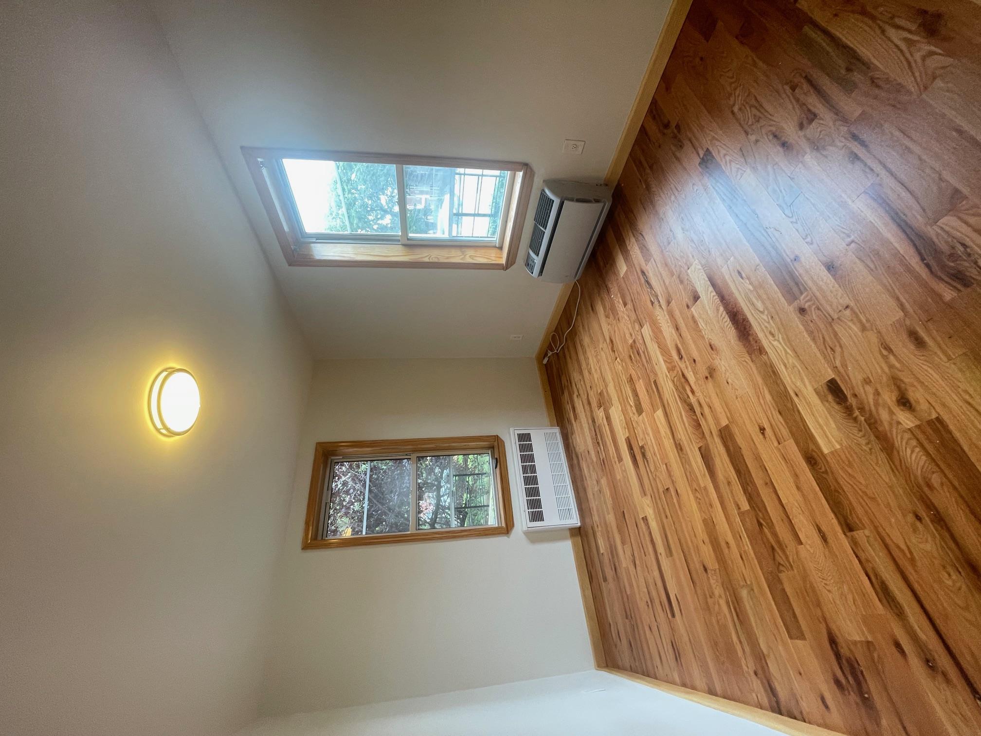 59-30 108th Street, Unit 2JJ Queens, NY 11368 - Photo 14 of 15 Spare room with wood finished floors and a wall unit AC