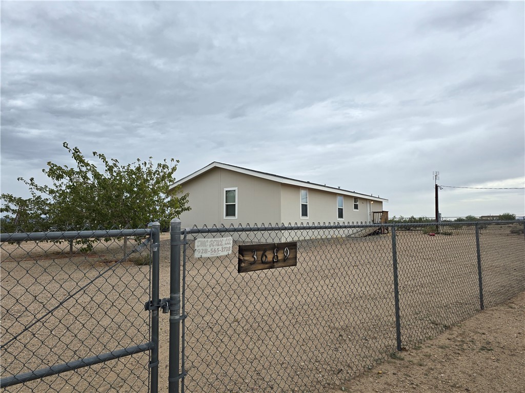 3689 North Avra Road Golden Valley, AZ 86413 - Photo 1 of 32 standing at gate entrance