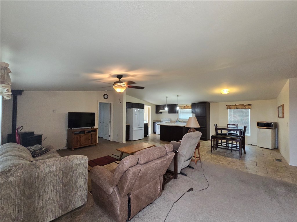 3689 North Avra Road Golden Valley, AZ 86413 - Photo 11 of 32 Carpeted living room with a ceiling fan and vaulted ceiling