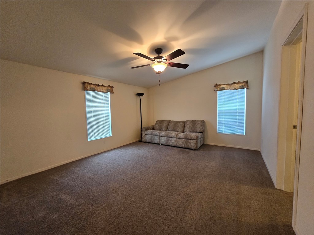 3689 North Avra Road Golden Valley, AZ 86413 - Photo 12 of 32 Unfurnished room featuring dark carpet, plenty of natural light, and ceiling fan