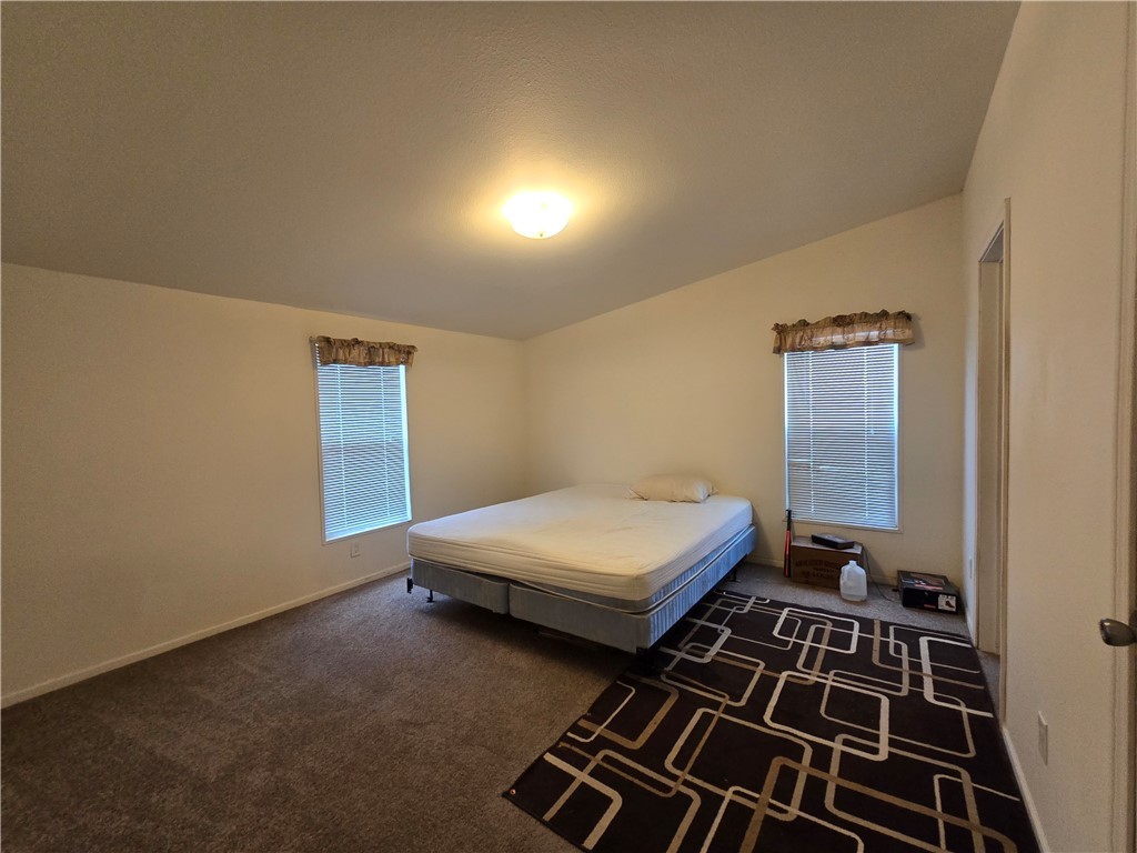 3689 North Avra Road Golden Valley, AZ 86413 - Photo 13 of 32 Bedroom featuring dark colored carpet and lofted ceiling