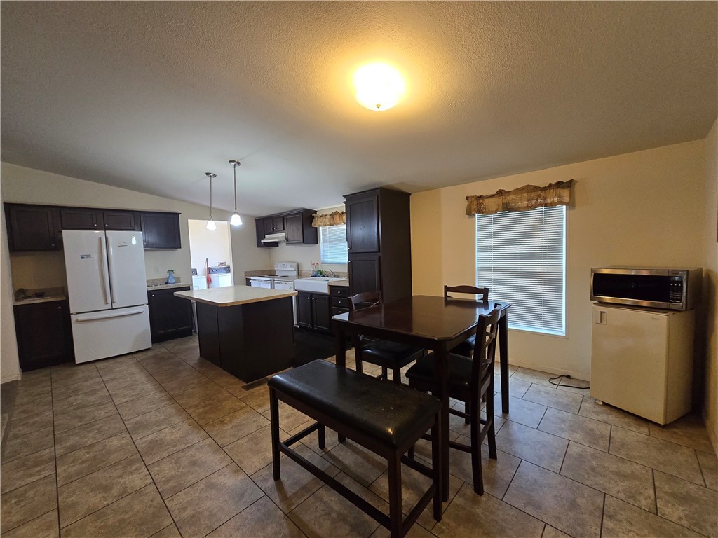 3689 North Avra Road Golden Valley, AZ 86413 - Photo 4 of 32 Dining area with lofted ceiling, dark tile patterned flooring, and a textured ceiling