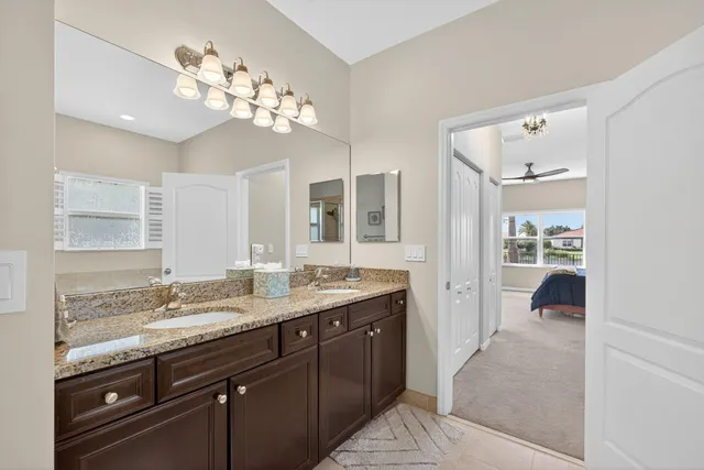 a bathroom with a granite countertop sink a mirror and shower