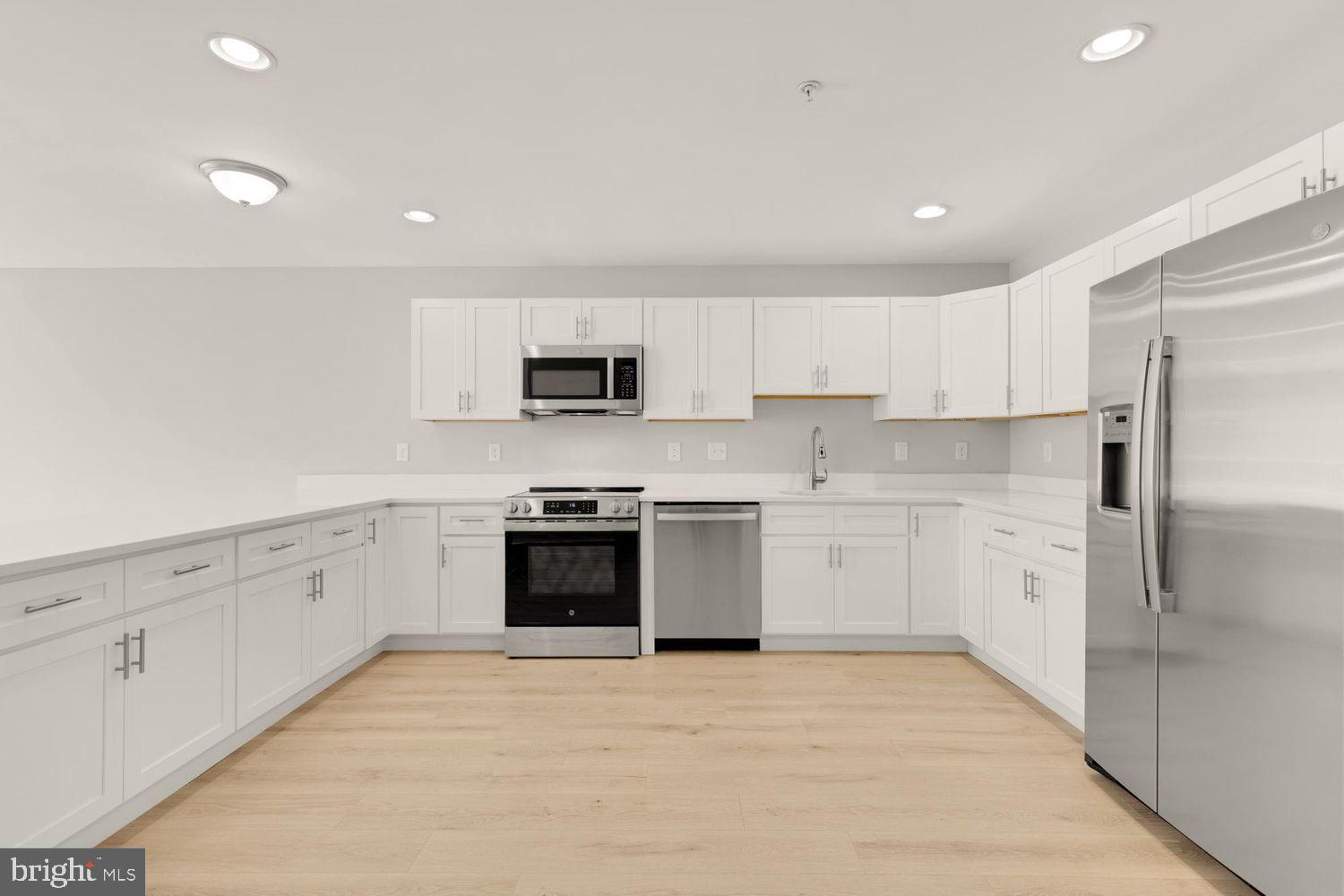 1755 W Street Southeast, Unit A Washington, DC 20020 - Photo 15 of 35 a kitchen with granite countertop white cabinets and stainless steel appliances