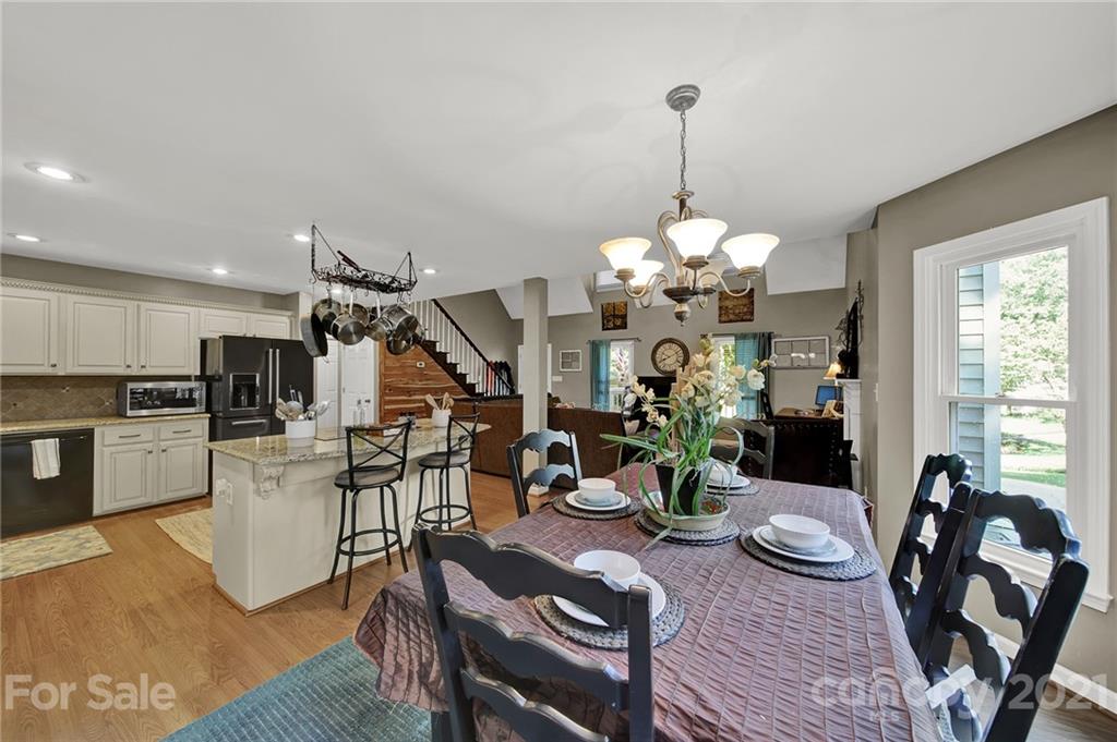 963 Pine Knoll Road Fort Mill, SC 29715 - Photo 5 of 23 a view of a dining room with furniture a chandelier and wooden floor