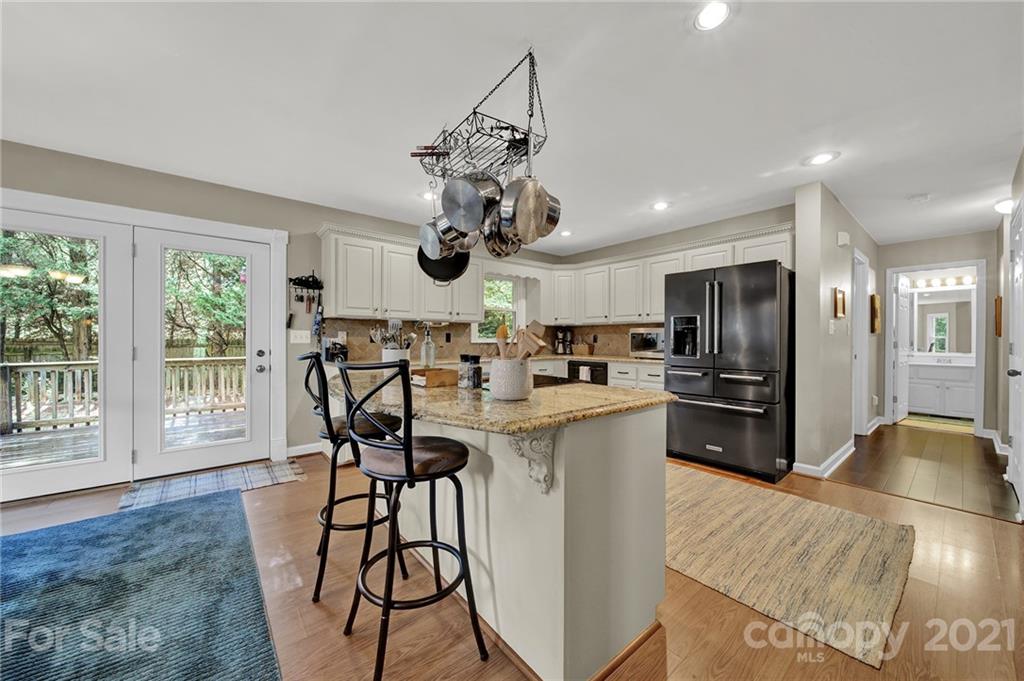 963 Pine Knoll Road Fort Mill, SC 29715 - Photo 7 of 23 a kitchen with stainless steel appliances granite countertop a stove top oven a refrigerator a sink and a dining table with wooden floor