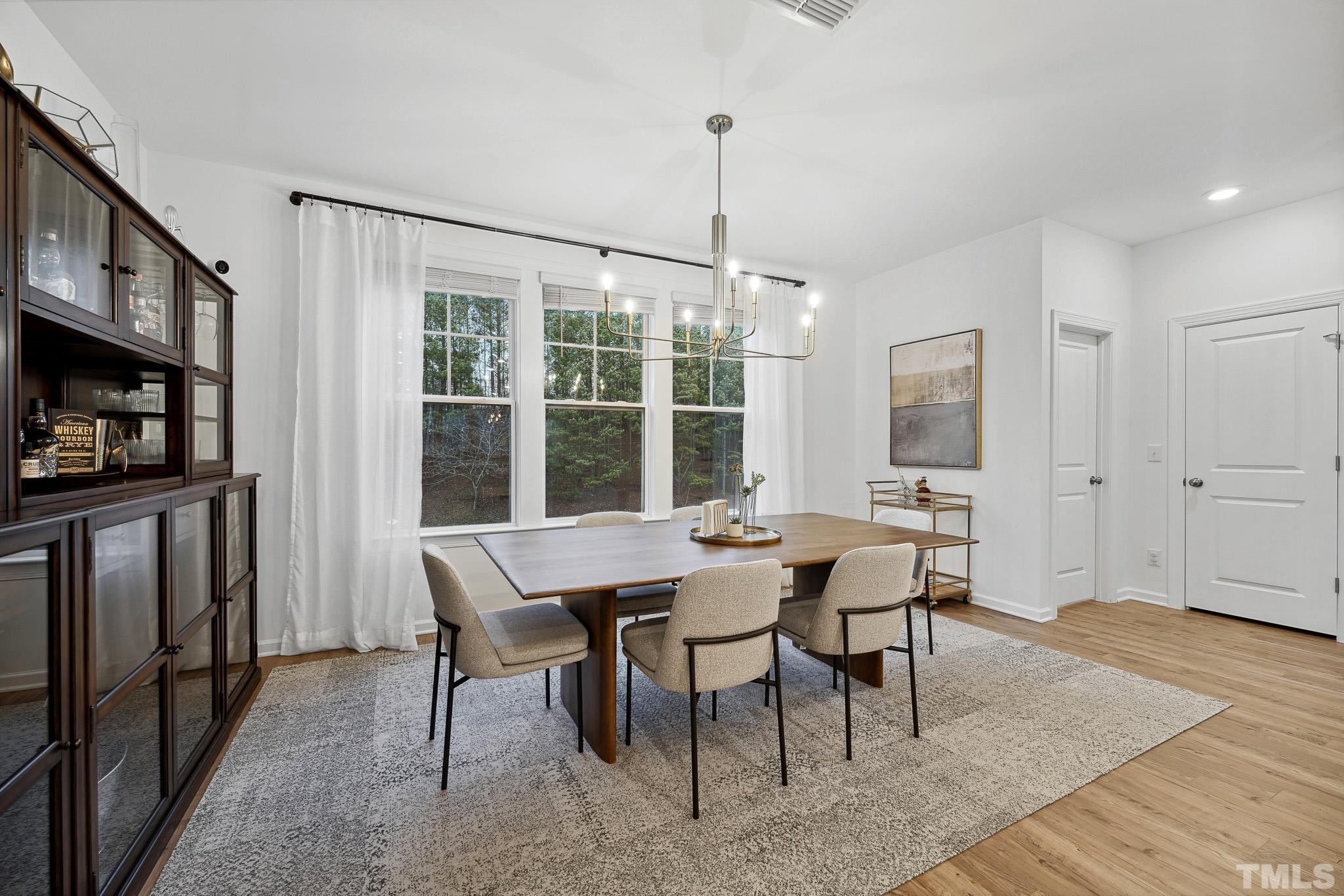 3251 Lynn Road Raleigh, NC 27613 - Photo 18 of 29 a view of a dining room with furniture window and wooden floor
