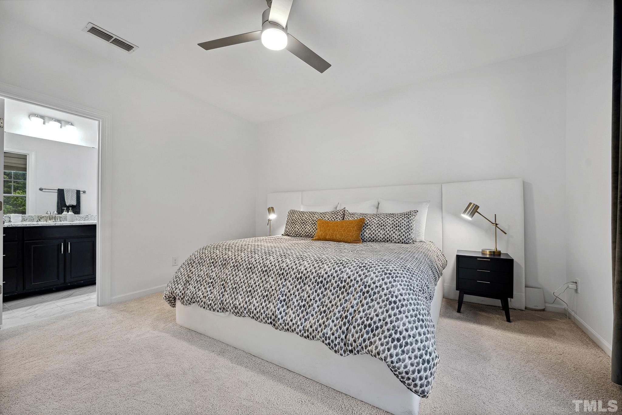 3251 Lynn Road Raleigh, NC 27613 - Photo 7 of 29 a bedroom with a bed and a chandelier