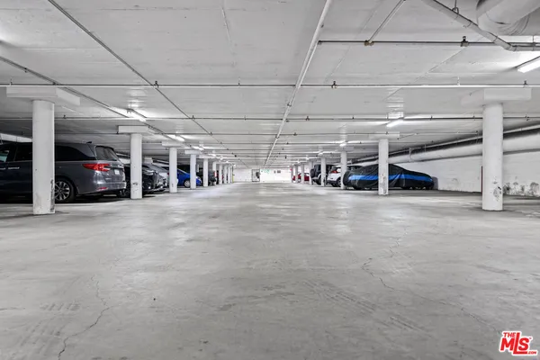 a sidewalk with a building and trees in the background