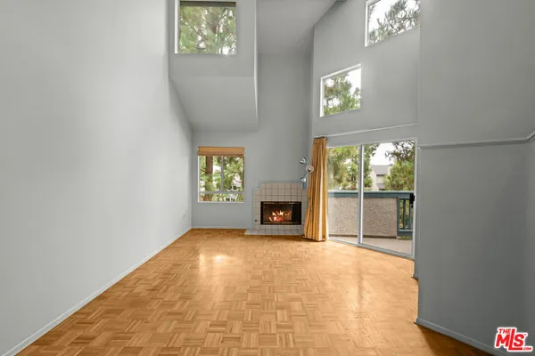 a living room with fireplace furniture and a large window