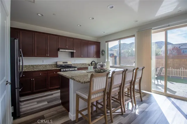 a kitchen with granite countertop wooden cabinets and stainless steel appliances