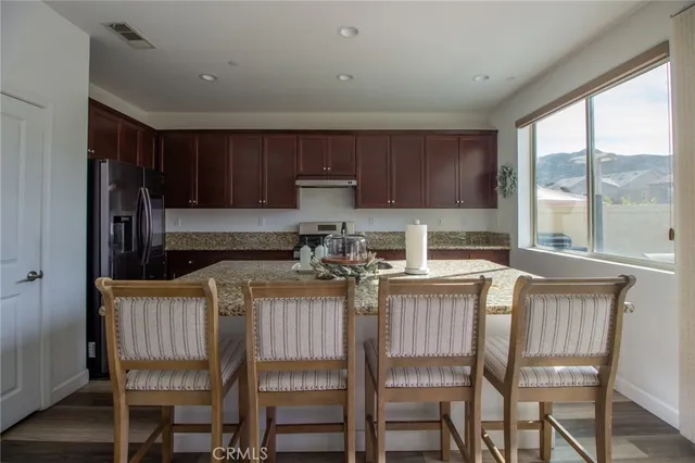 a kitchen with a stove a refrigerator and wooden cabinets