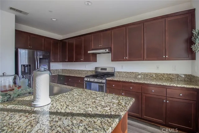 a kitchen with stainless steel appliances granite countertop a stove a sink dishwasher and cabinets