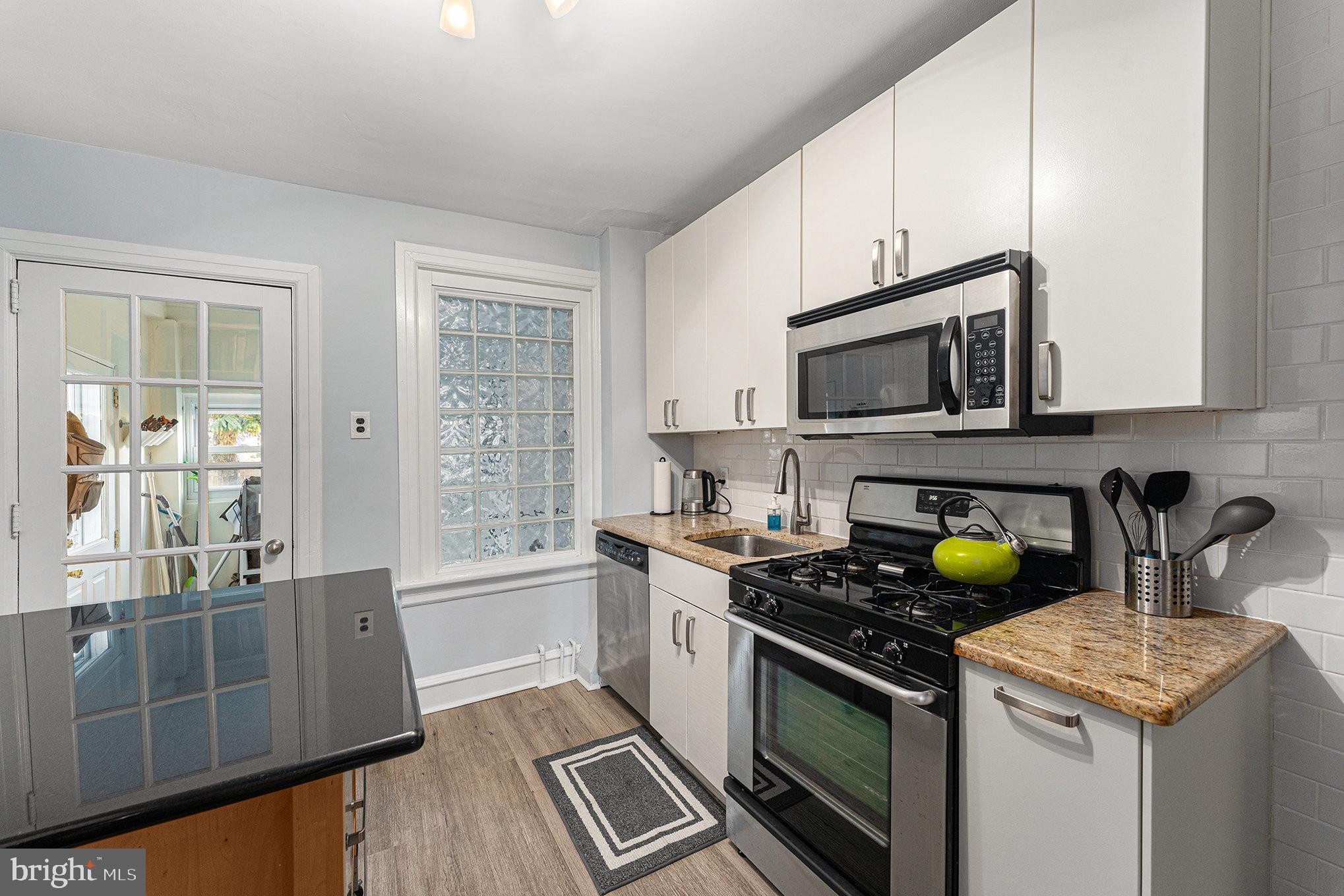 14 Springfield Avenue Flourtown, PA 19031 - Photo 15 of 34 a kitchen with stainless steel appliances a stove a sink cabinets and a window
