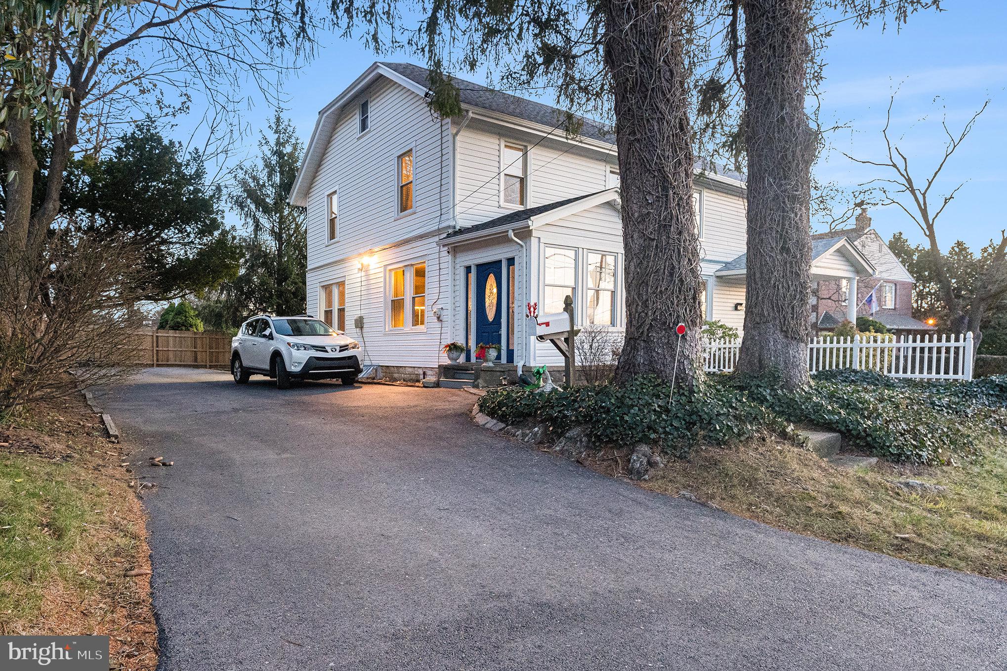 14 Springfield Avenue Flourtown, PA 19031 - Photo 4 of 34 a view of a white house with large trees and parked cars
