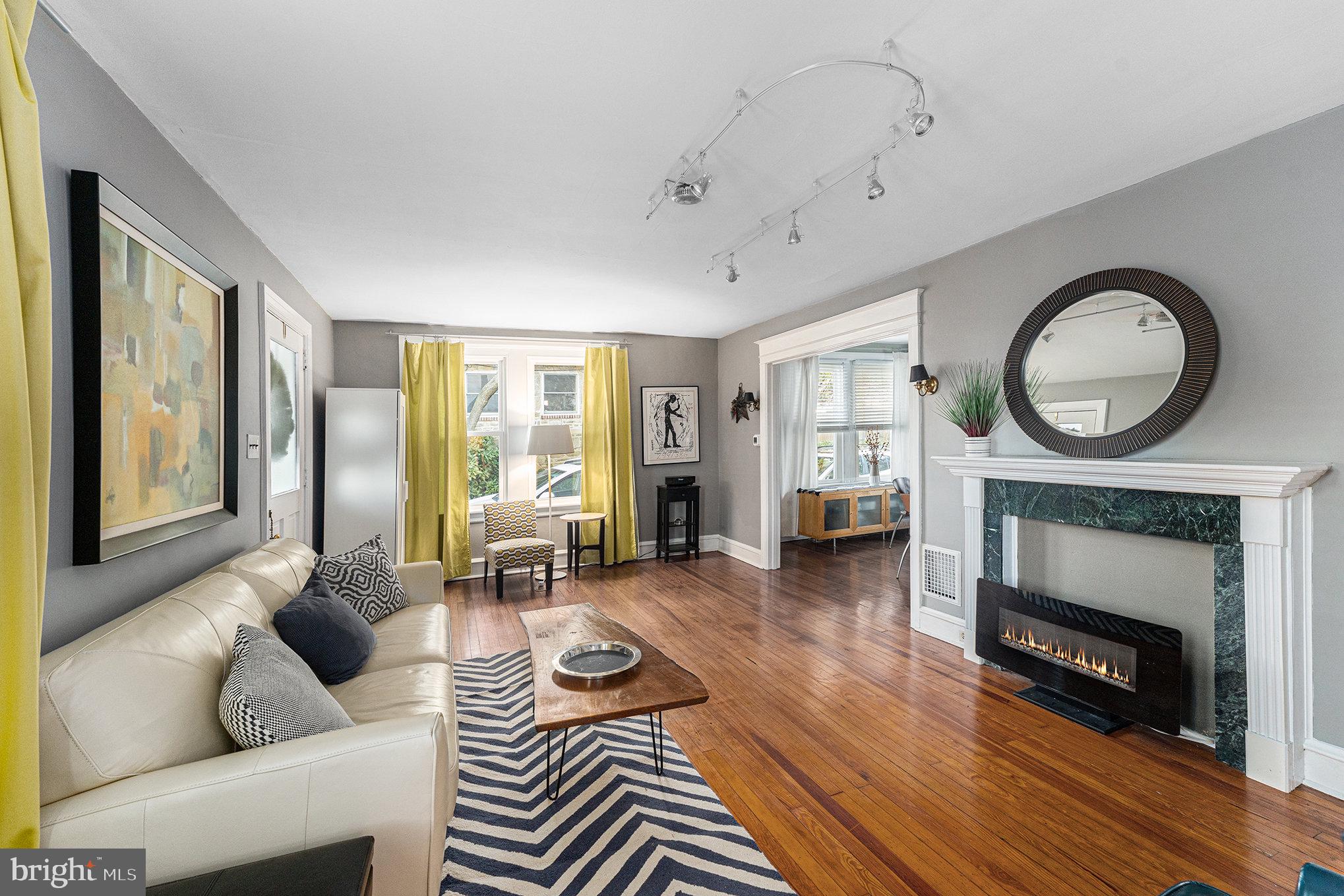 14 Springfield Avenue Flourtown, PA 19031 - Photo 10 of 34 a living room with furniture a fireplace a flat screen tv and a large window