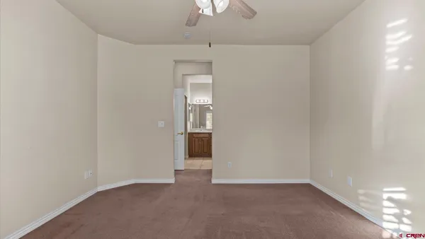 an empty room with a chandelier fan