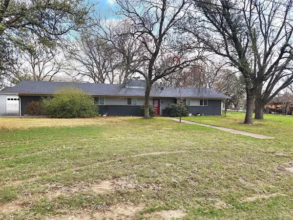 a view of a house with a yard and trees