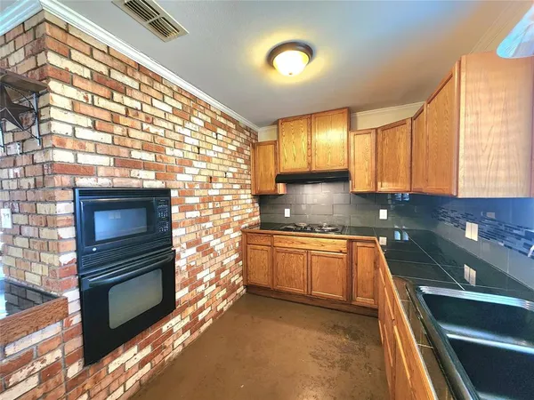 a kitchen with granite countertop stainless steel appliances a stove a sink and a window