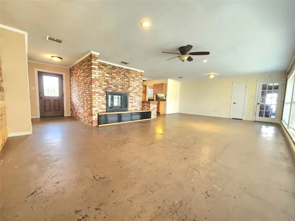 an empty room with windows and fan view