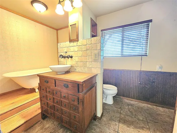 a bathroom with a sink a toilet and a mirror