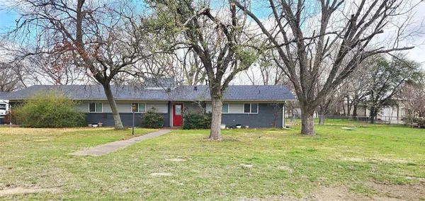 a view of a house with a yard and large tree