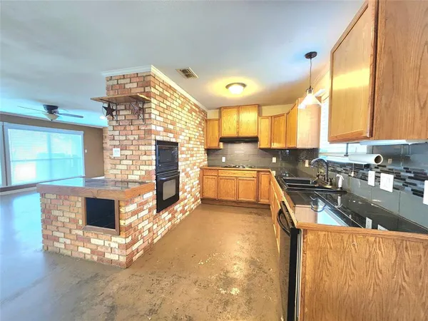 a kitchen with stainless steel appliances granite countertop a stove a sink and a microwave