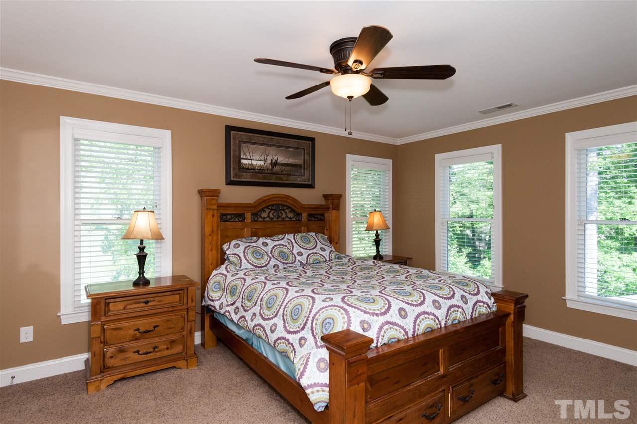 2620 Jasper Lane Raleigh, NC 27613 - Photo 14 of 25 a bedroom with a bed a window and a chandelier