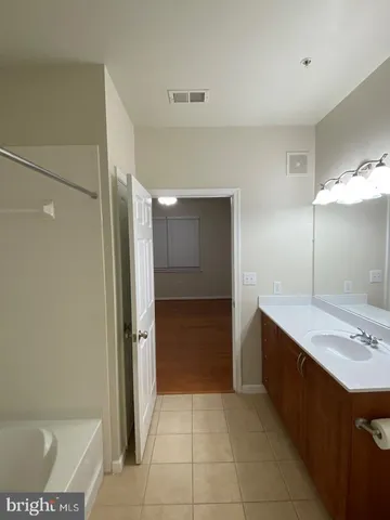 a view of a hallway with wooden floor and cabinet