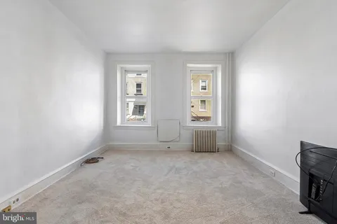 an empty room with windows and closet