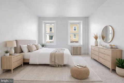a bedroom with bed and a large window