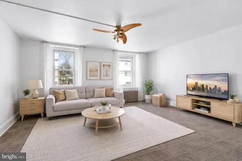 a living room with furniture a rug and a flat screen tv