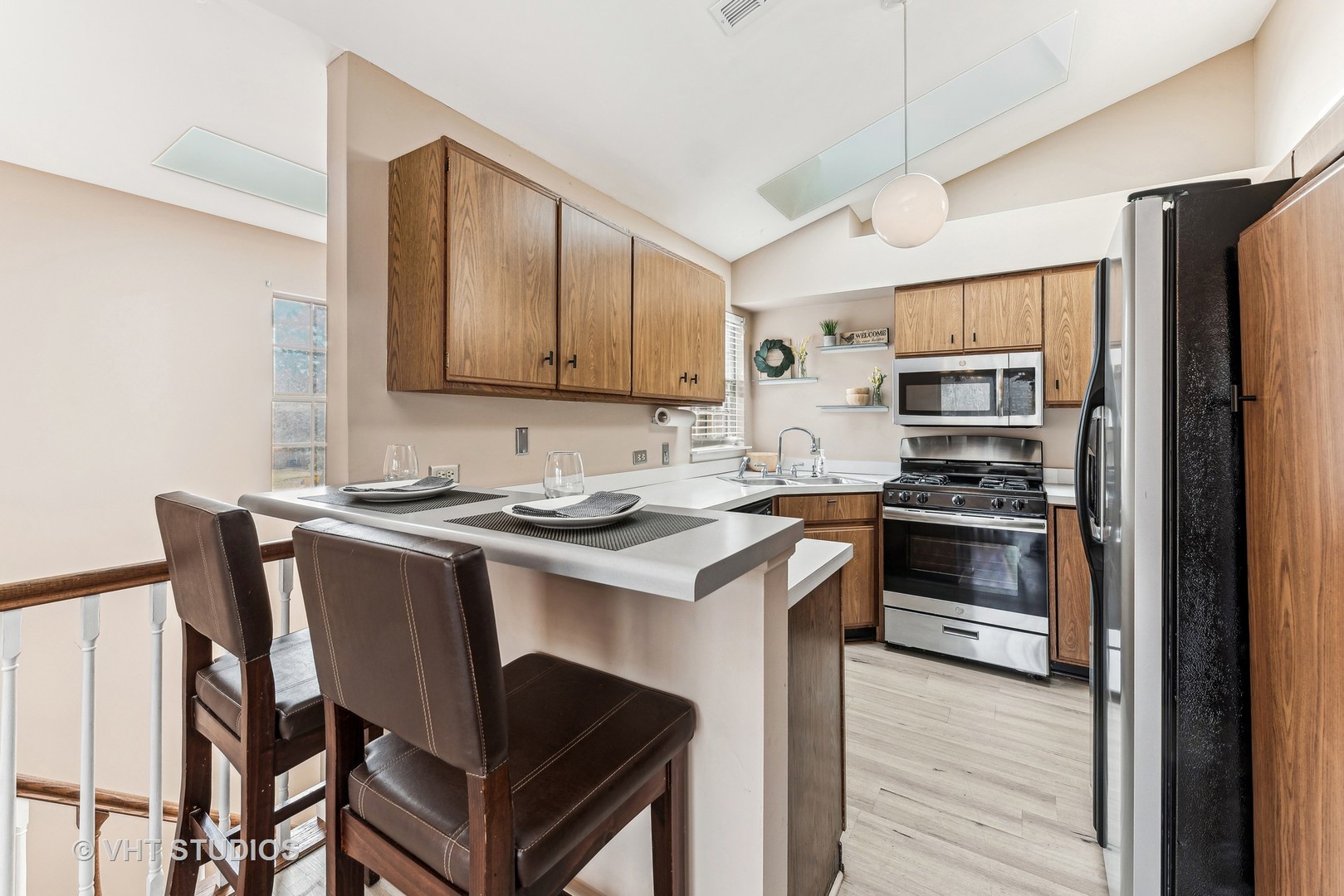 918 Ridgefield Lane Wheeling, IL 60090 - Photo 5 of 22 a kitchen with stainless steel appliances a stove a sink refrigerator and a refrigerator with wooden floor