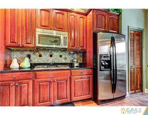 16 Pebble Creek Road Dayton, NJ 08810 - Photo 10 of 25 a kitchen with stainless steel appliances granite countertop a refrigerator and a sink