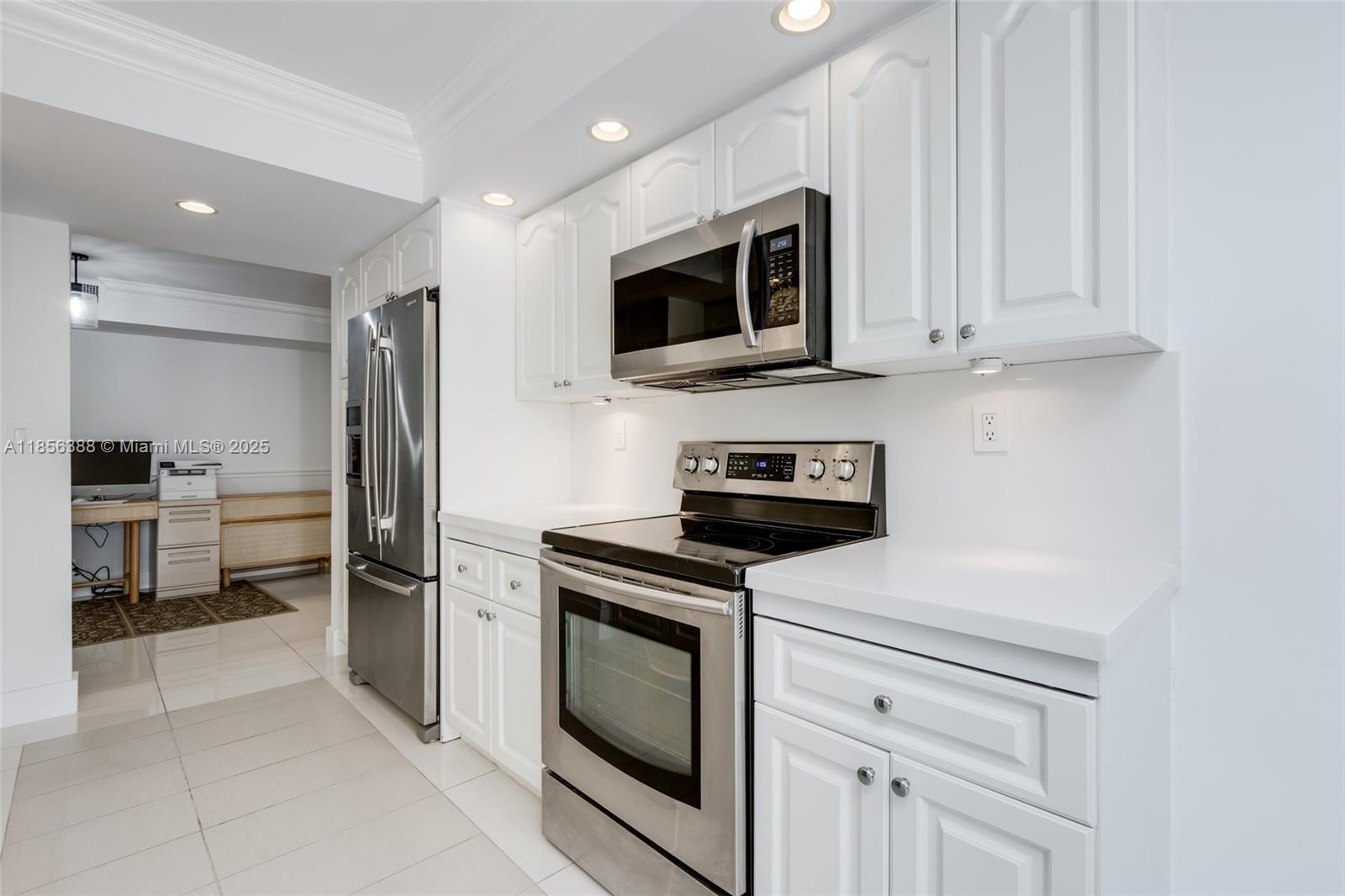 2000 Towerside Terrace, Unit 406 Miami, FL 33138 - Photo 11 of 56 a kitchen with stainless steel appliances granite countertop white cabinets and a stove a oven with white countertops