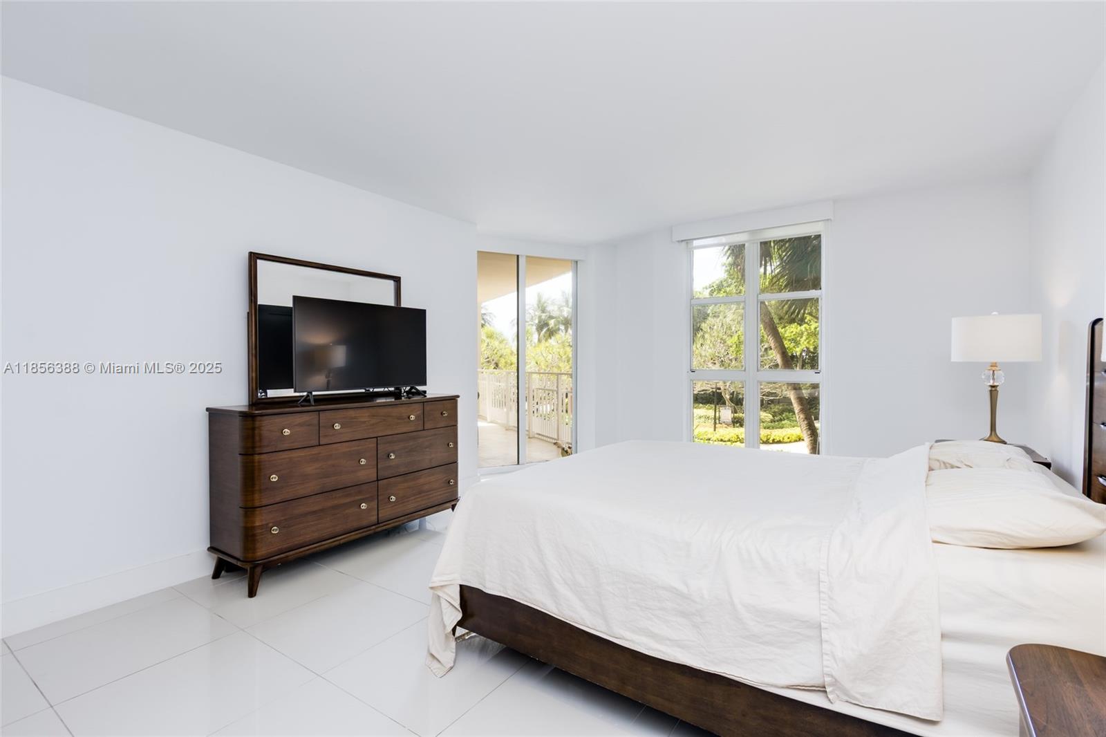 2000 Towerside Terrace, Unit 406 Miami, FL 33138 - Photo 20 of 56 a bedroom with a bed and flat screen tv