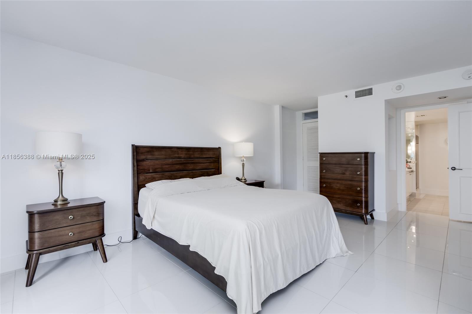 2000 Towerside Terrace, Unit 406 Miami, FL 33138 - Photo 22 of 56 a bedroom with a bed and a lamp on table