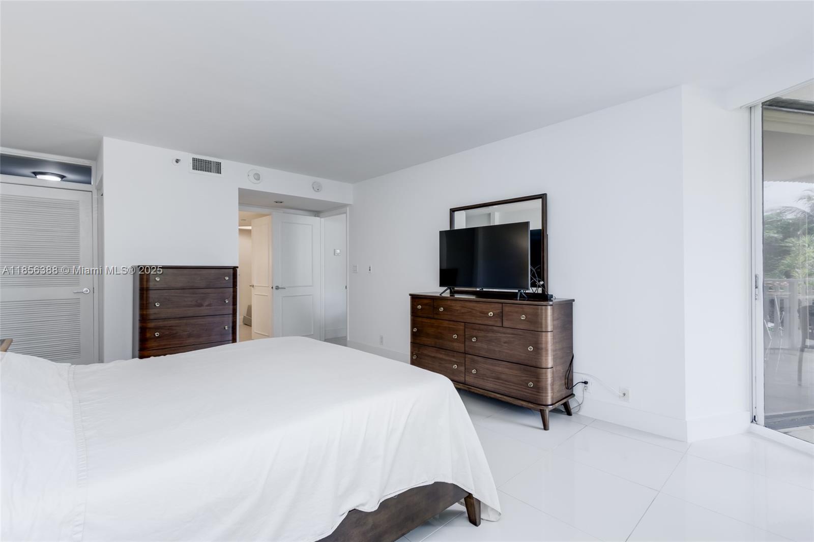 2000 Towerside Terrace, Unit 406 Miami, FL 33138 - Photo 23 of 56 a bedroom with a bed and flat screen tv