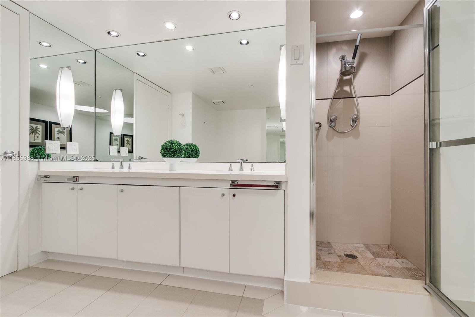 2000 Towerside Terrace, Unit 406 Miami, FL 33138 - Photo 24 of 56 a bathroom with a double vanity sink a mirror and a shower