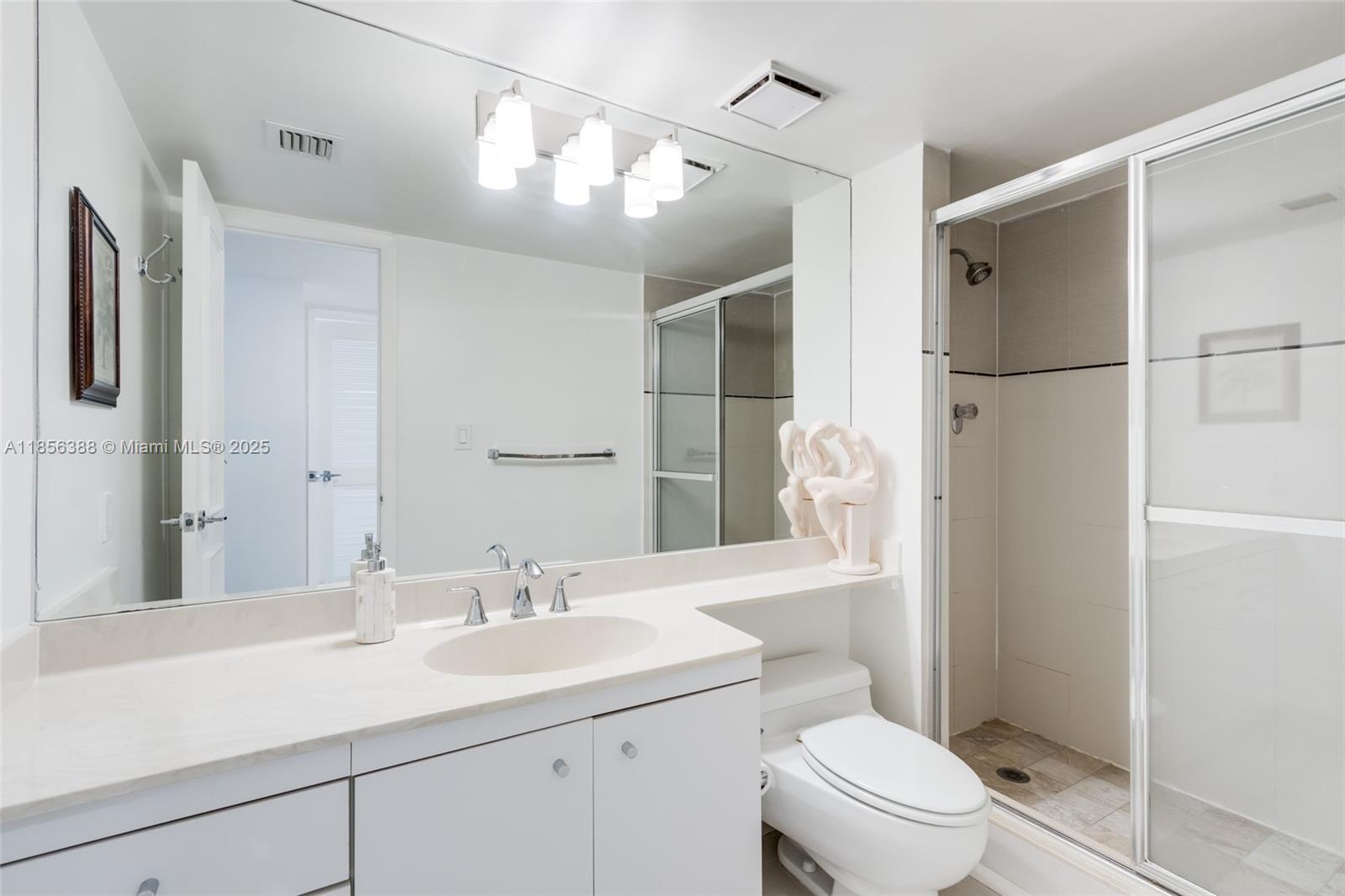 2000 Towerside Terrace, Unit 406 Miami, FL 33138 - Photo 32 of 56 a bathroom with a sink toilet double vanity and shower