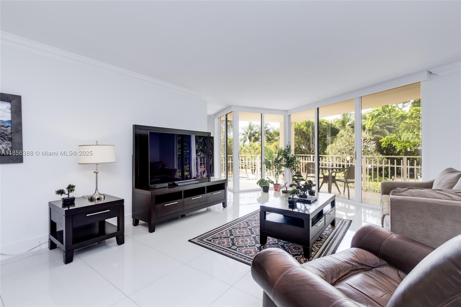 2000 Towerside Terrace, Unit 406 Miami, FL 33138 - Photo 6 of 56 a living room with furniture and a flat screen tv