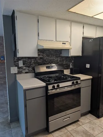 a stove top oven sitting inside of a kitchen